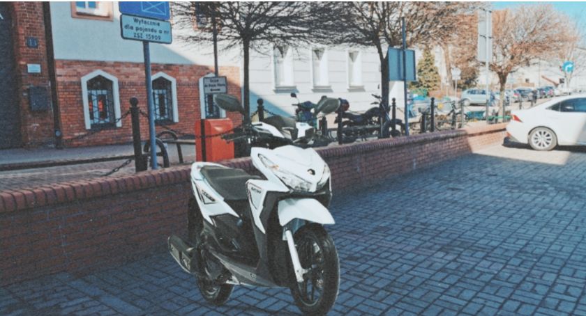 Skuter urzędniczy parkujący na wydzielonym dla limuzyny burmistrza miejscu