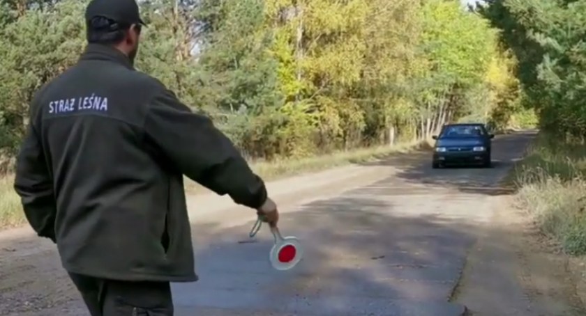 zdjęcie: Straż Leśna zatrzymuje do kontroli samochód poruszający się po leśnej drodze / fot: RDLP