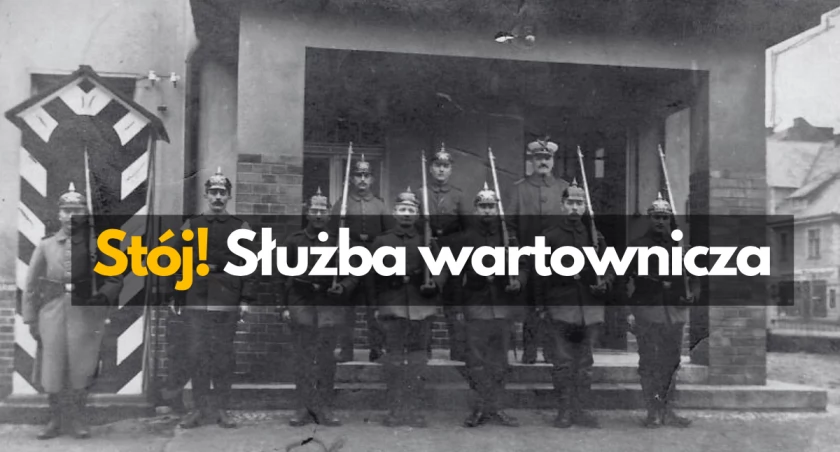 zdjęcie: Na schodach wartowni (biura przepustek) żołnierze w pikielhaubach wraz ze swoim dowódcą pozują do zdjęcia. 