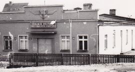 Dom Kultury Kolejarza w 1970 rok. Od ulicy ogradza go betonowy płot z wykrzywioną...